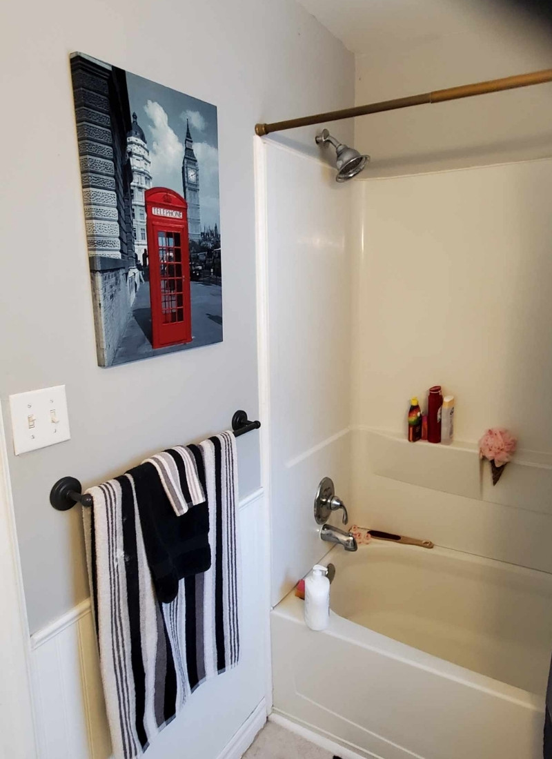 Tub and bathroom wall with shower curtain rod